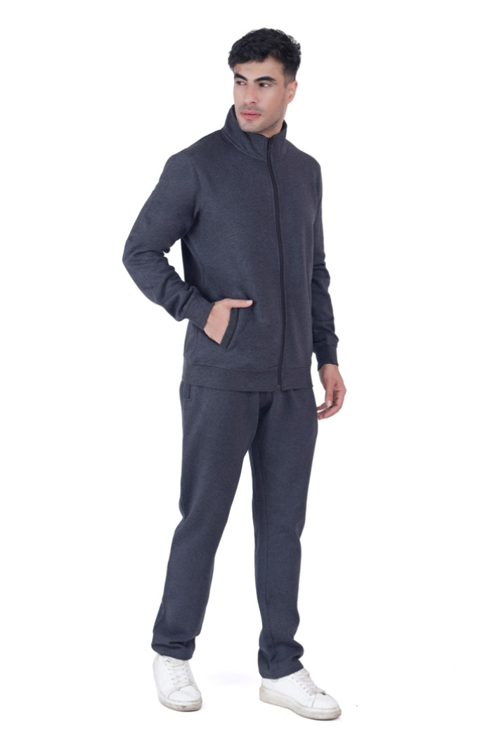 A man in Coatsnmore’s Super Anthra zip-up tracksuit with a high collar, standing in a confident pose with one hand in his pocket and the other relaxed, wearing white sneakers against a white background.